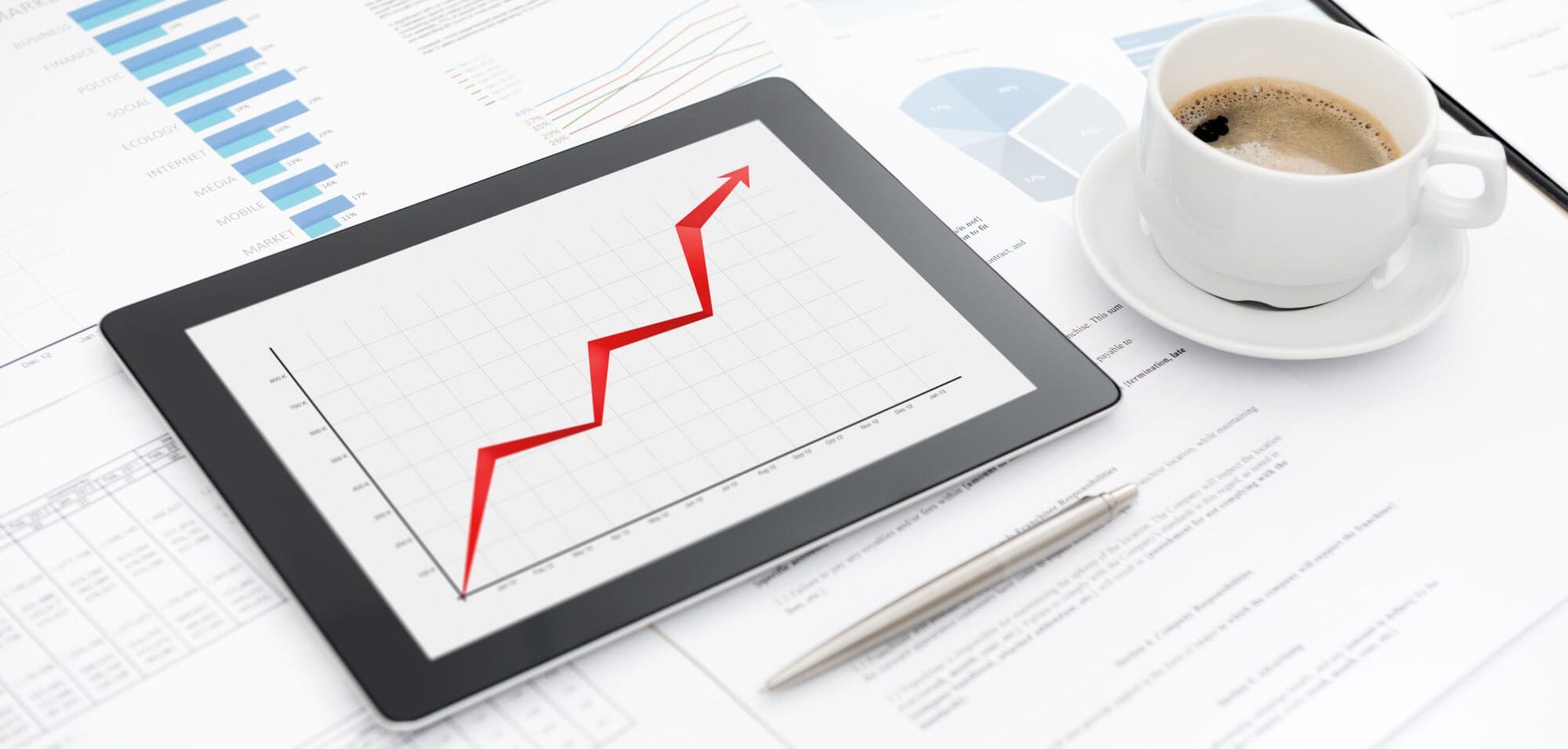 Raising Line chart on tablet next to coffee cup