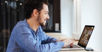 Man Smiling While Using Computer